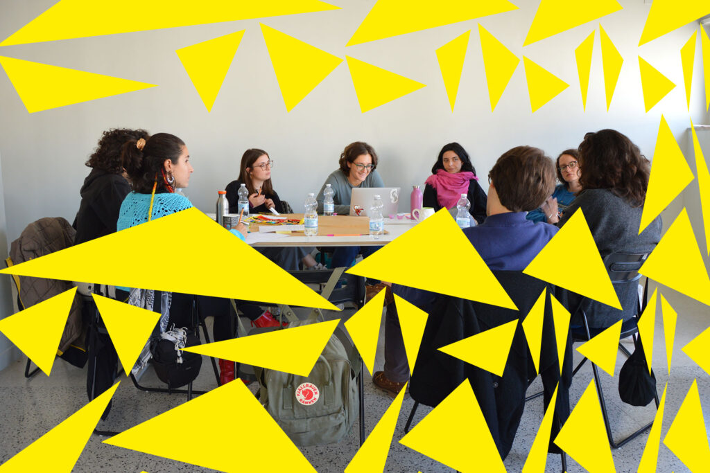 Un tavolo e un gruppo di giovani intorno a discutere. Triangoli gialli irregolari invadono l'immagine.
