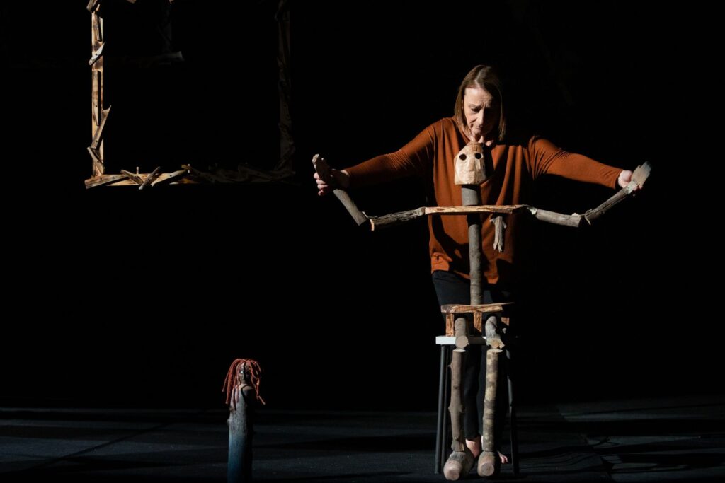 una donna vestita di rosso manovra un automata in legno